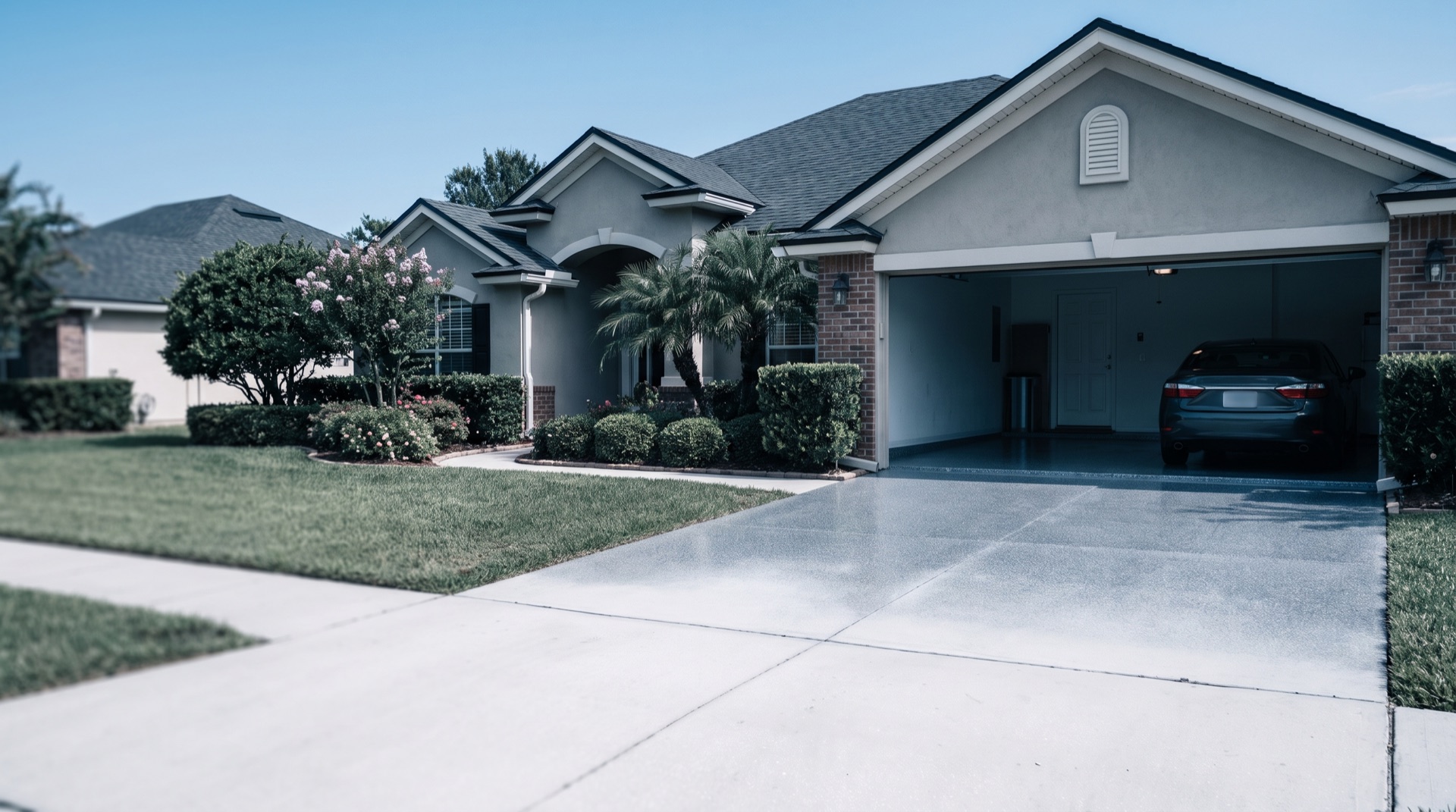 Coated garage floor and driveway on an Orange Park family home with a glossy grey flake finish